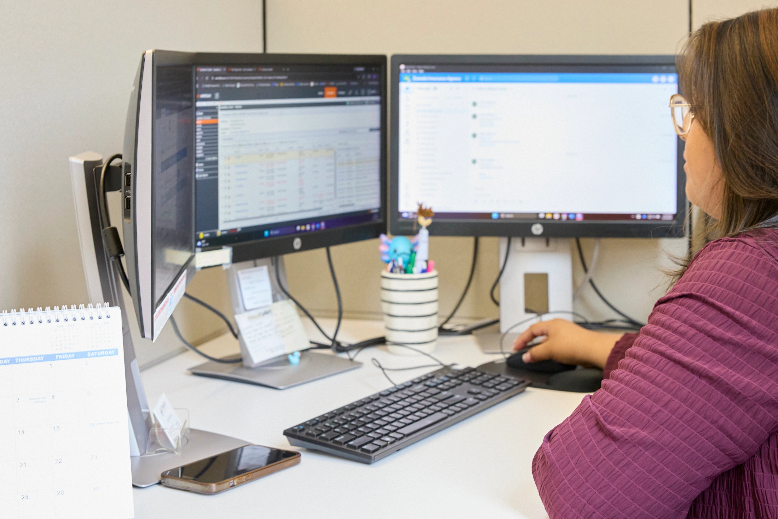 Insurance agent working at dual-monitor desktop workstation